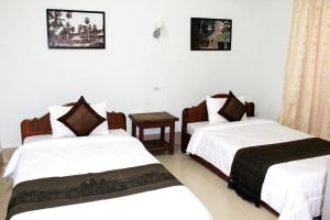 a hotel room with two beds and a table at Tropical Breeze in Siem Reap