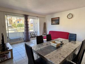 a dining room with a table and a red couch at Appartement en centre-ville avec balcon, garage et animaux admis - Collioure - FR-1-225-705 in Collioure +16 photos