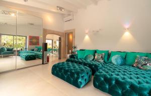 a living room with a large green couch and chairs at Ca'n Fanals in Alcudia