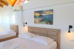 a bedroom with two beds and a painting on the wall at Hotel Golden Oak in Ksamil