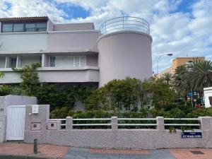 a white lighthouse in front of a building at OFF Ciudad Jardin in Las Palmas de Gran Canaria