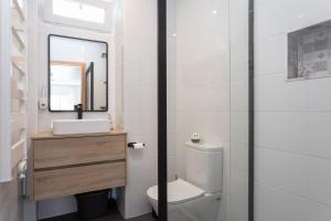 ein Badezimmer mit Toilette, Waschbecken und Spiegel in der Unterkunft Lush Botanic Oasis with a Boho Hideaway, Near Beach & Cafés in Lagos + 27 Fotos