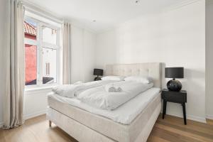 ベルゲンにあるScandinavian Luxury in Bergen's Finest Streetの白いベッドルーム(大型ベッド1台、窓付)