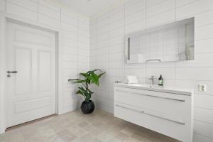 ベルゲンにあるScandinavian Luxury in Bergen's Finest Streetの洗面台と鏡のある白いバスルーム +36枚の写真