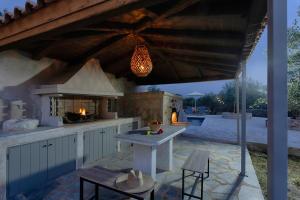 an outdoor kitchen with a table and a stove at Ethos Retreat, Luxury Villas in Areopoli