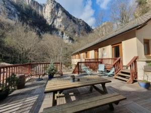 a wooden deck with a picnic table on a house at Logis Hotel Le Moulin De La Pipe in Plan-de-Baix