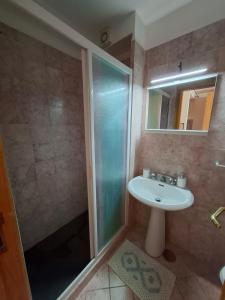 Un baño con lavabo y ducha de cristal. en Le Camerelle 83, en Capri 10 fotos más