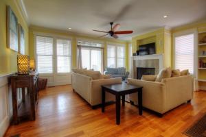 Una sala de estar con dos sofás y un ventilador de techo. en Salty Banana by Carolina Beach Realty, en Kure Beach