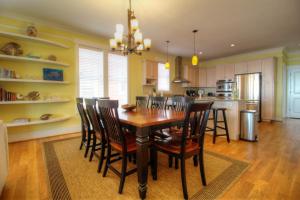 Una cocina y un comedor con mesa y sillas de madera. en Salty Banana by Carolina Beach Realty, en Kure Beach 82 fotos más