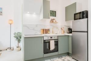 a kitchen with a stove and a refrigerator at Lavande Dorée in Avignon