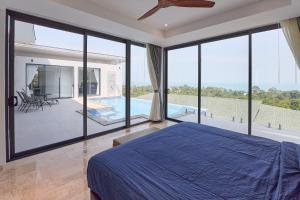 a bedroom with a blue bed and a large window at Sea view Villa Josefina - 3 bedroom in Nathon Bay +43 photos