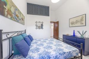 a bedroom with a bed with blue pillows and a dresser at Fiori di Mare in Le Foci