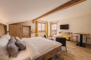 1 dormitorio con 1 cama y sala de estar con escritorio. en Birkhof, en Lana
