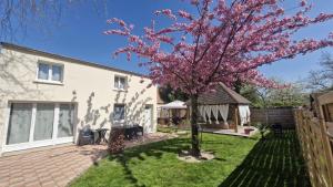a magnolia tree in the yard of a house at Les Trois Palmiers - Jardin & Spa privatifs in Les Bréviaires