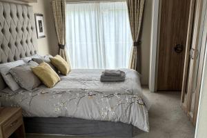 una camera da letto con un letto grande con una grande finestra di Edinburgh Lodge-Sleeps 6-Pet Friendly-Beach&Views a Prestonpans