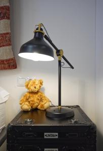 a teddy bear sitting on top of a desk under a lamp at Osito Hub - l'Explorador Andrés in Valencia
