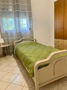 a bedroom with a bed with a green blanket at Ellegant apartment in Politika in Politika