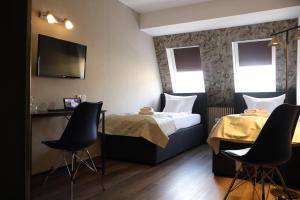 a hotel room with a bed and two chairs at Gästehaus Dresdner Hof in Zittau