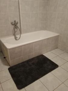 a bath tub in a bathroom with a black rug at Petrovická chalupa in Petrovice u Susice