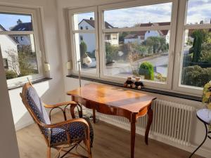 a room with a table and chairs and windows at Ferienwohnung Alte Post Retzen in Bad Salzuflen