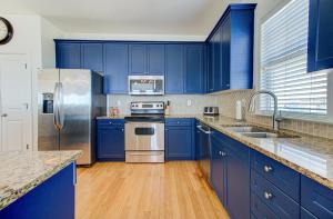 een blauwe keuken met roestvrijstalen apparatuur en blauwe kasten bij Sandstep by Carolina Beach Realty in Carolina Beach