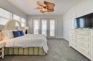 een slaapkamer met een bed en een flatscreen-tv bij Sandstep by Carolina Beach Realty in Carolina Beach