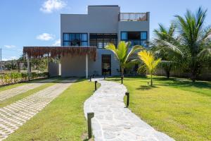 une maison avec un chemin en pierre devant elle dans l'établissement Casa Mar Kaak - Conforto e Privacidade na Praia do Marceneiro - Com Serviço, à Passo de Camarajibe