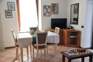 a living room with a table and chairs and a television at Casa Marina in San Pellegrino Terme