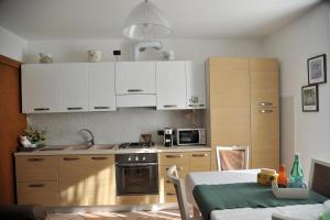 a small kitchen with white cabinets and a table with a tableablish at Casa Marina in San Pellegrino Terme