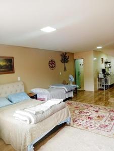 een kamer met drie bedden en een tapijt bij Hospedaria Dona Clara in Tiradentes +18 foto's