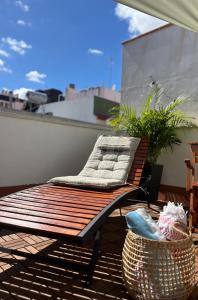 a wooden bench sitting on a balcony with a basket at Sunny Cozy & Pretty Penthouse in Central SC in Santa Cruz de Tenerife