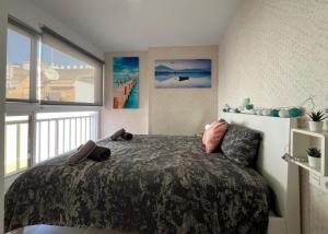 a bedroom with a bed and a large window at Sunny Cozy & Pretty Penthouse in Central SC in Santa Cruz de Tenerife