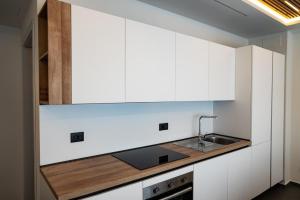 a kitchen with white cabinets and a sink at TOLU - Design Apartment - City Center in Reggio di Calabria +2 photos