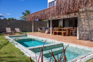 une maison avec une piscine et une terrasse en bois dans l'établissement Casa Mar Kaak - Conforto e Privacidade na Praia do Marceneiro - Com Serviço, à Passo de Camarajibe