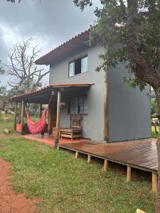 a house with a hammock outside of it at Aconchego da Lapinha in Santana do Riacho