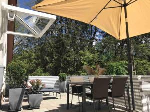 a table and chairs with an umbrella on a patio at Ferienwohnung Landliebe in Pfullendorf