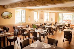 a restaurant with tables and chairs and windows at Hôtel Henri IV - Restaurant in Eauze