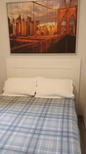 a bed in a room with a painting on the wall at Casa Marcé in Córdoba