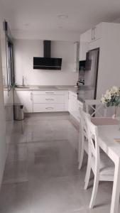 a white kitchen with a table and a refrigerator at Casa Marcé in Córdoba