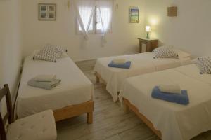 a room with three beds and a window at Casa Armonia in Illes Balears