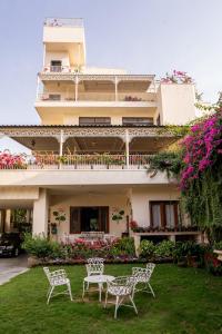 a building with two chairs and a table in the yard at Dera Jaipur Homestay in Jaipur