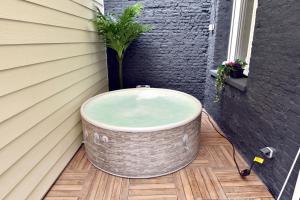 a bath tub sitting on a deck next to a building at Le Bleu OMER - Jacuzzi & Netflix - Terrasse privée I Coeur de ville & Transports - Idéal FAMILLE - OFFRE SPÉCIALE in Saint-Omer