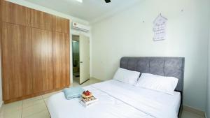 a bedroom with a white bed with a wooden cabinet at Alanis Suite Homestay Fully Air-Con Suite Nilai KLIA in Sepang +13 photos