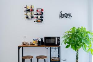 a table with two stools and a microwave and a plant at Casa Del Sole in Lanciano