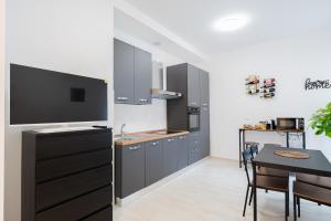 a kitchen with gray cabinets and a table with a dining room at Casa Del Sole in Lanciano