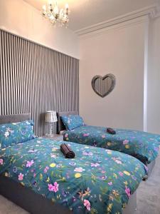 Un dormitorio con dos camas y un corazón en la pared. en Amazing Central House, en Blackpool