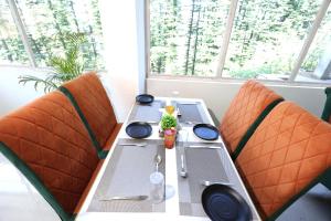 a table with two orange chairs and a table with a toy at White Castle Himalayan View by Lavender Hotels in Shimla +20 photos