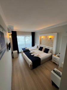 ein großes Schlafzimmer mit 2 Betten und einem Sofa in der Unterkunft Marla Didim Otel in Didim