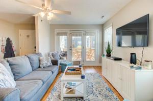 un soggiorno con un divano blu e una TV a schermo piatto di Sea Drift 200: Breezy by Carolina Beach Realty a Carolina Beach