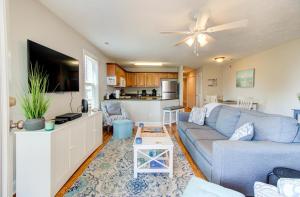 un soggiorno con un divano blu e una cucina di Sea Drift 200: Breezy by Carolina Beach Realty a Carolina Beach Altre 28 foto